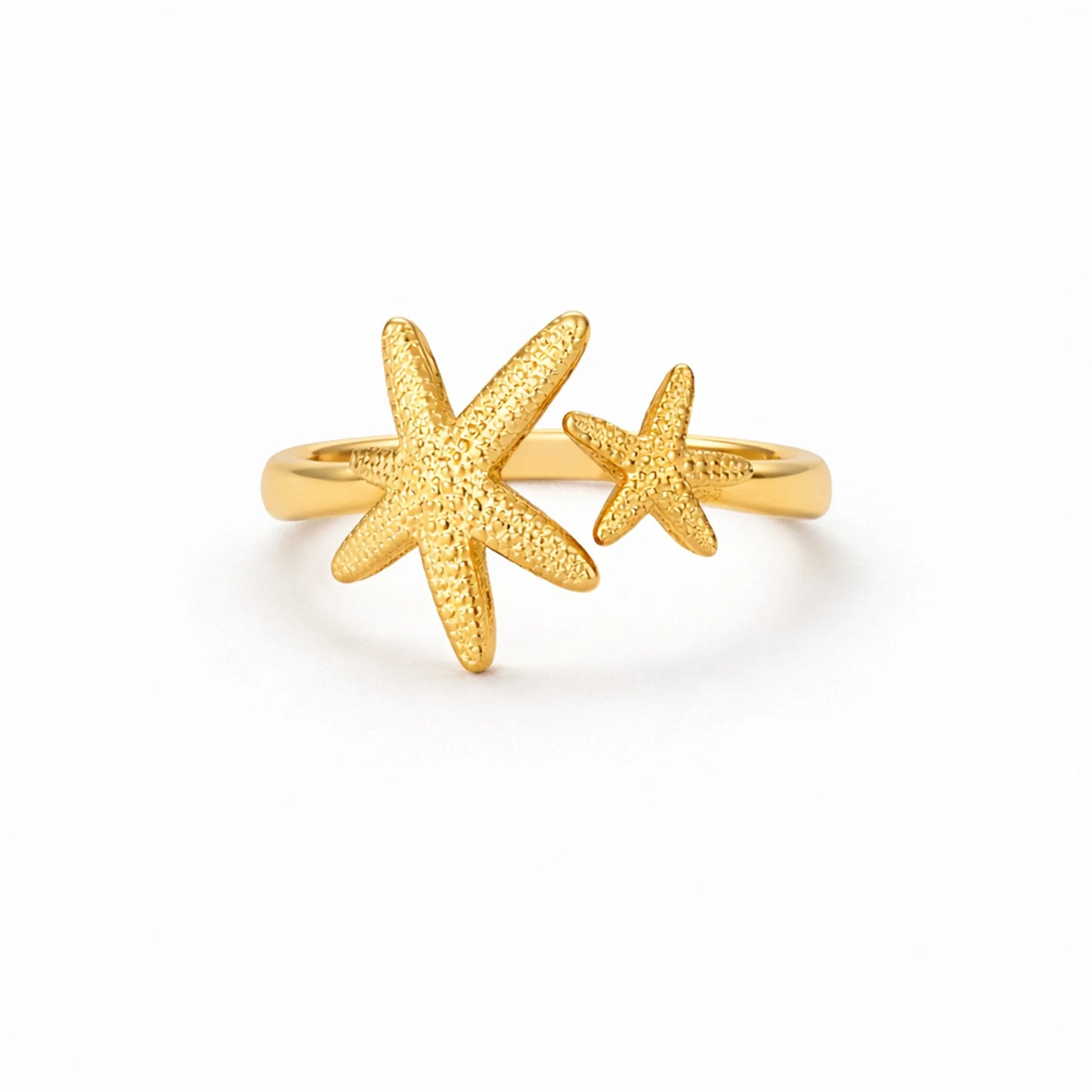Gold starfish adjustable ring with textured double star design on white background