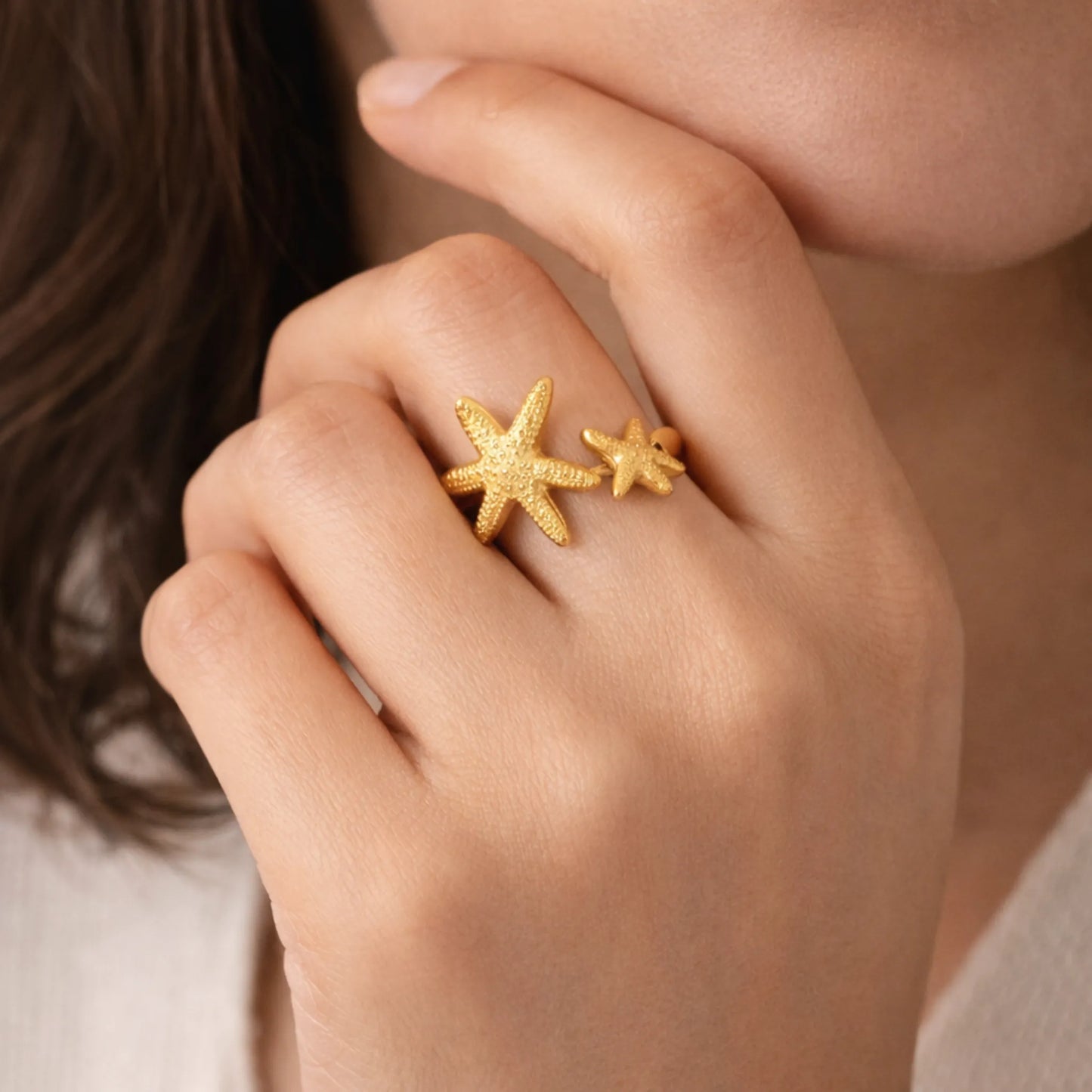 Model wearing gold starfish adjustable ring showcasing textured star design on finger