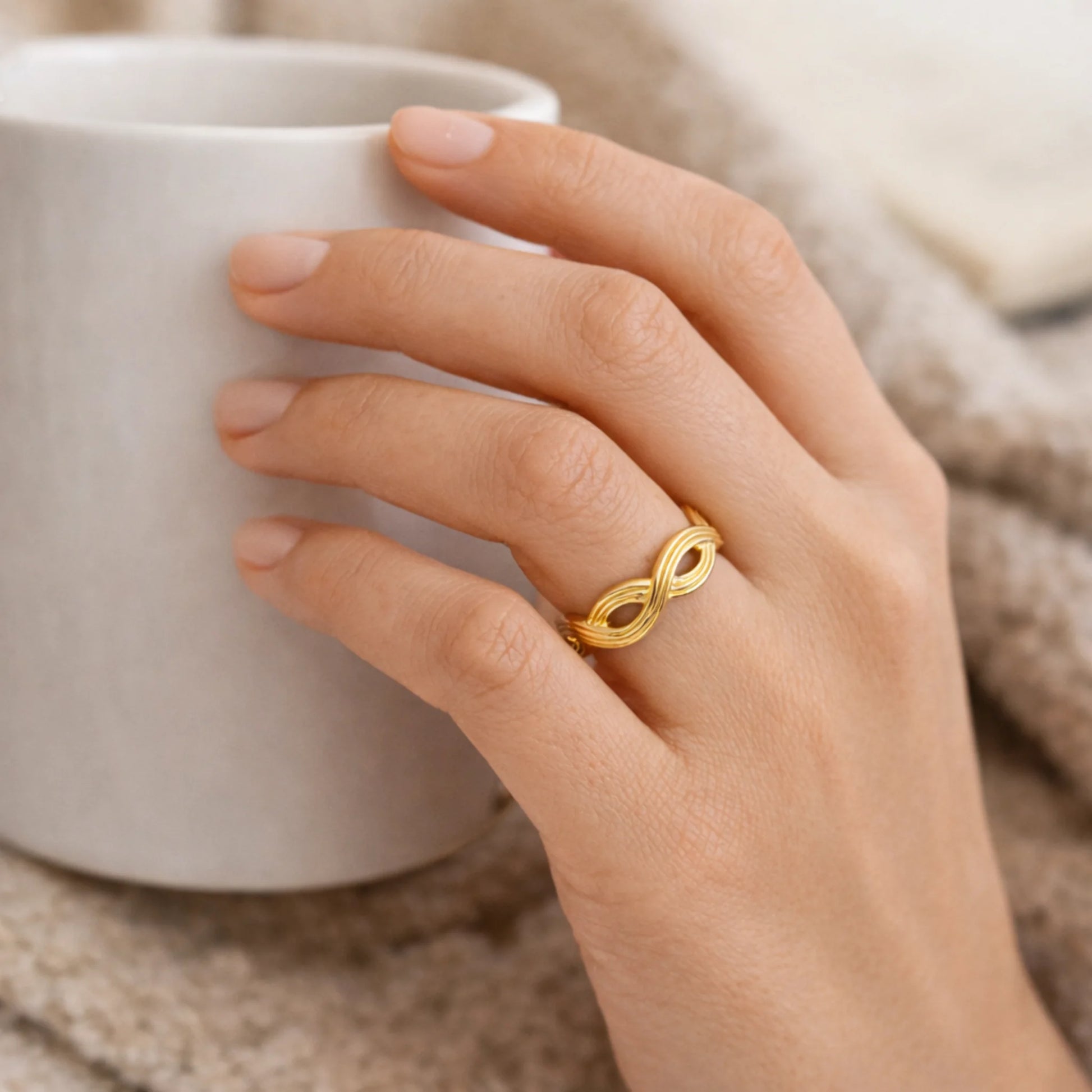 Yubiraa infinity knot gold ring worn on finger minimalist jewelry style