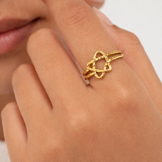 Minimal gold star ring worn on finger, open star design in anti-tarnish gold finish