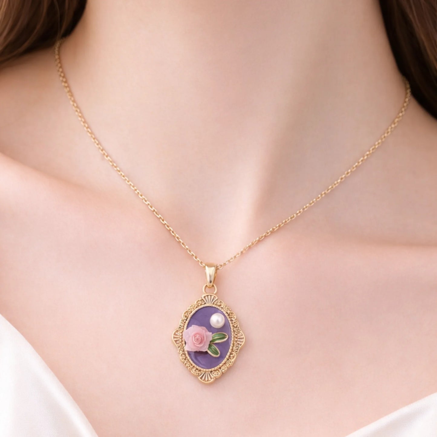Gold necklace with a floral pendant on a person wearing a white top