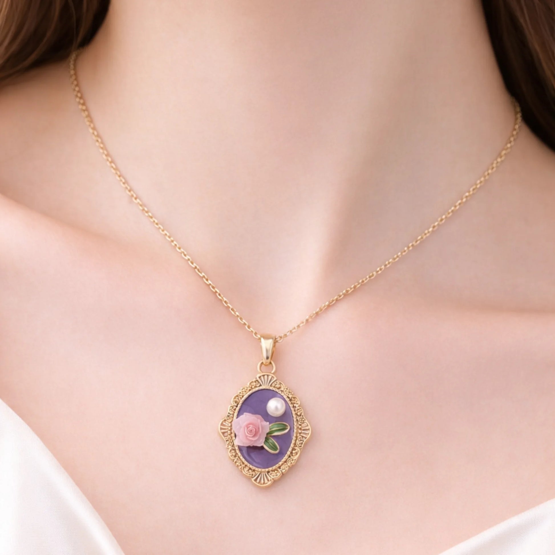 Gold necklace with a floral pendant on a person wearing a white top