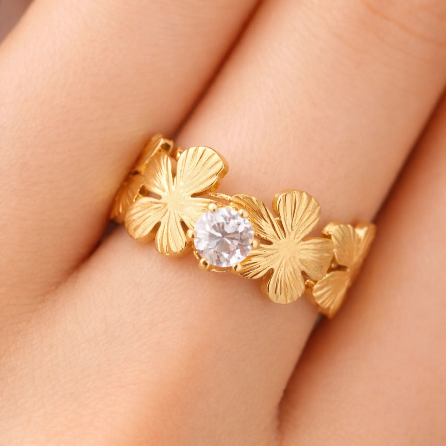 Model wearing gold love in bloom flower ring with sparkling solitaire stone and floral petal design – yubiraa