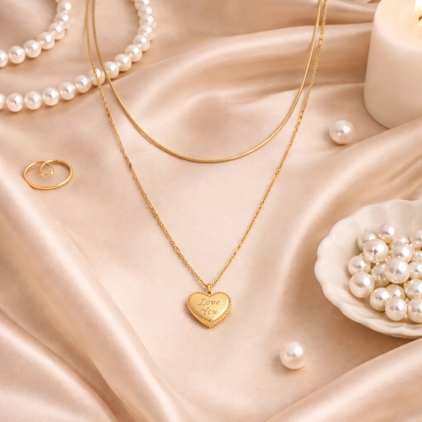 Gold plated anti tarnish double layered necklace with heart pendant on a beige fabric background