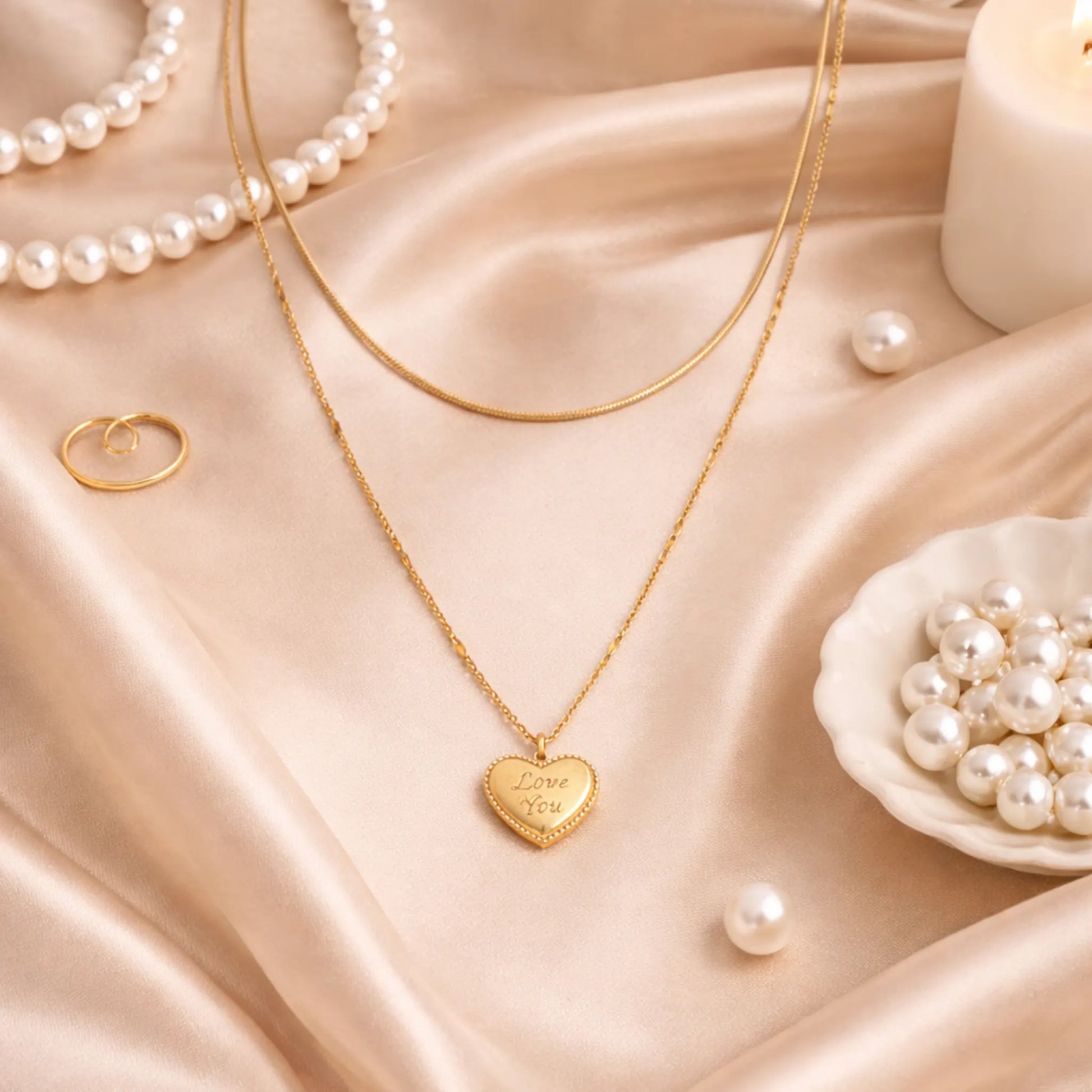 Gold plated anti tarnish double layered necklace with heart pendant on a beige fabric background