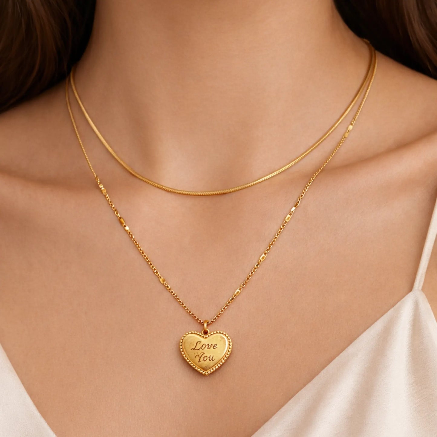 Gold plated anti tarnish double layered necklace with a heart-shaped pendant on a person wearing a white top.