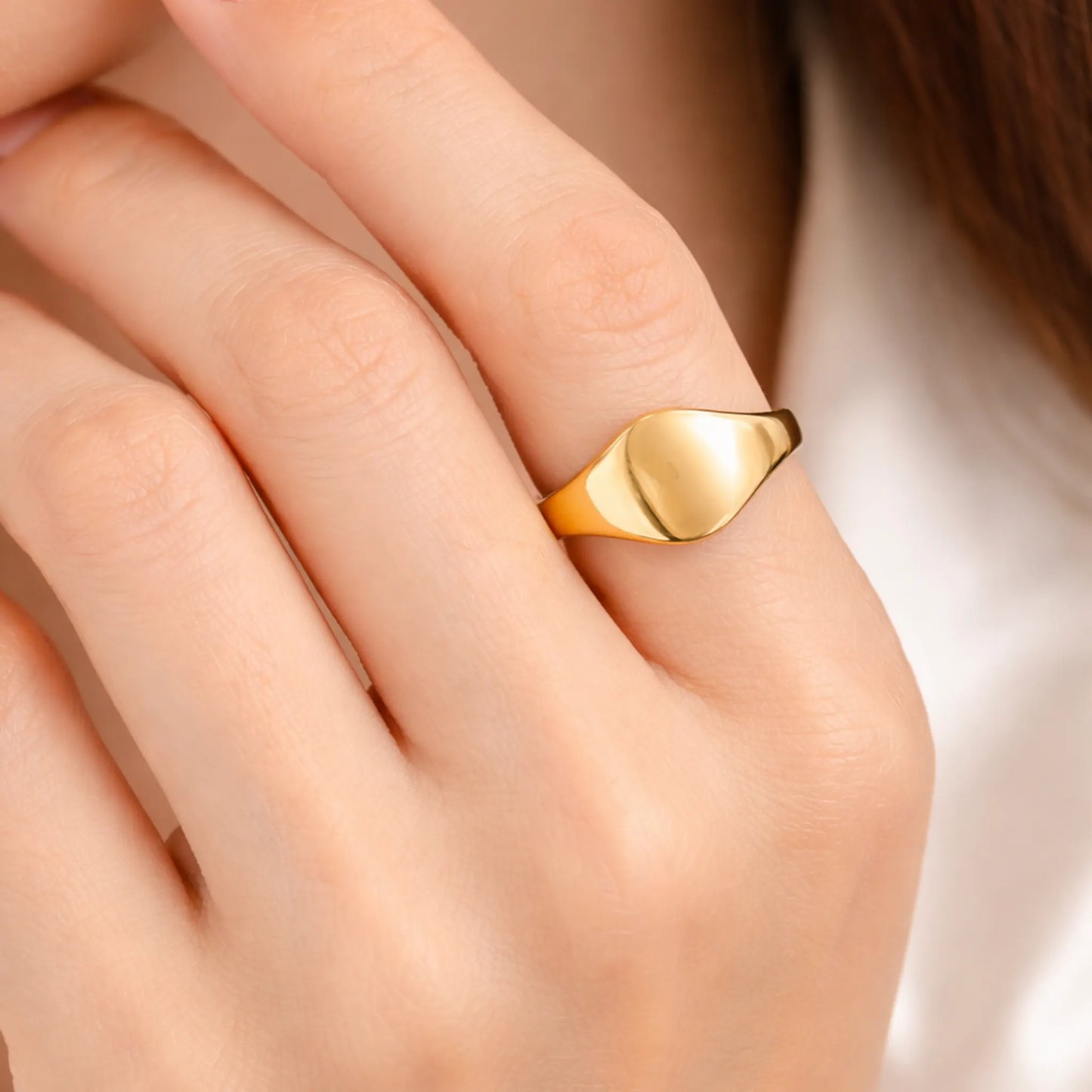 Model wearing gold polished signet ring showcasing minimal design
