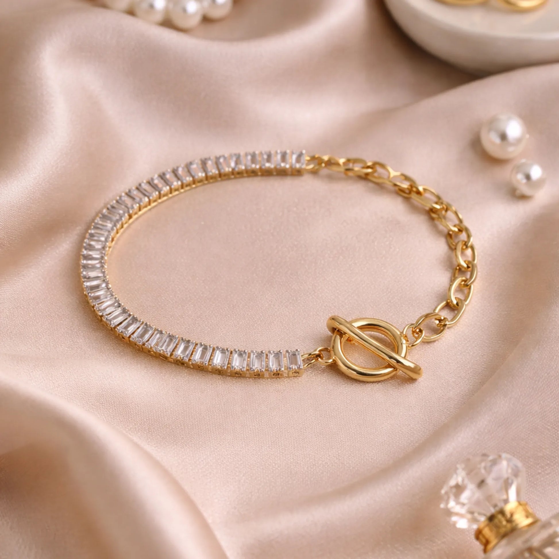 Gold bracelet with clear gemstones on a beige fabric background