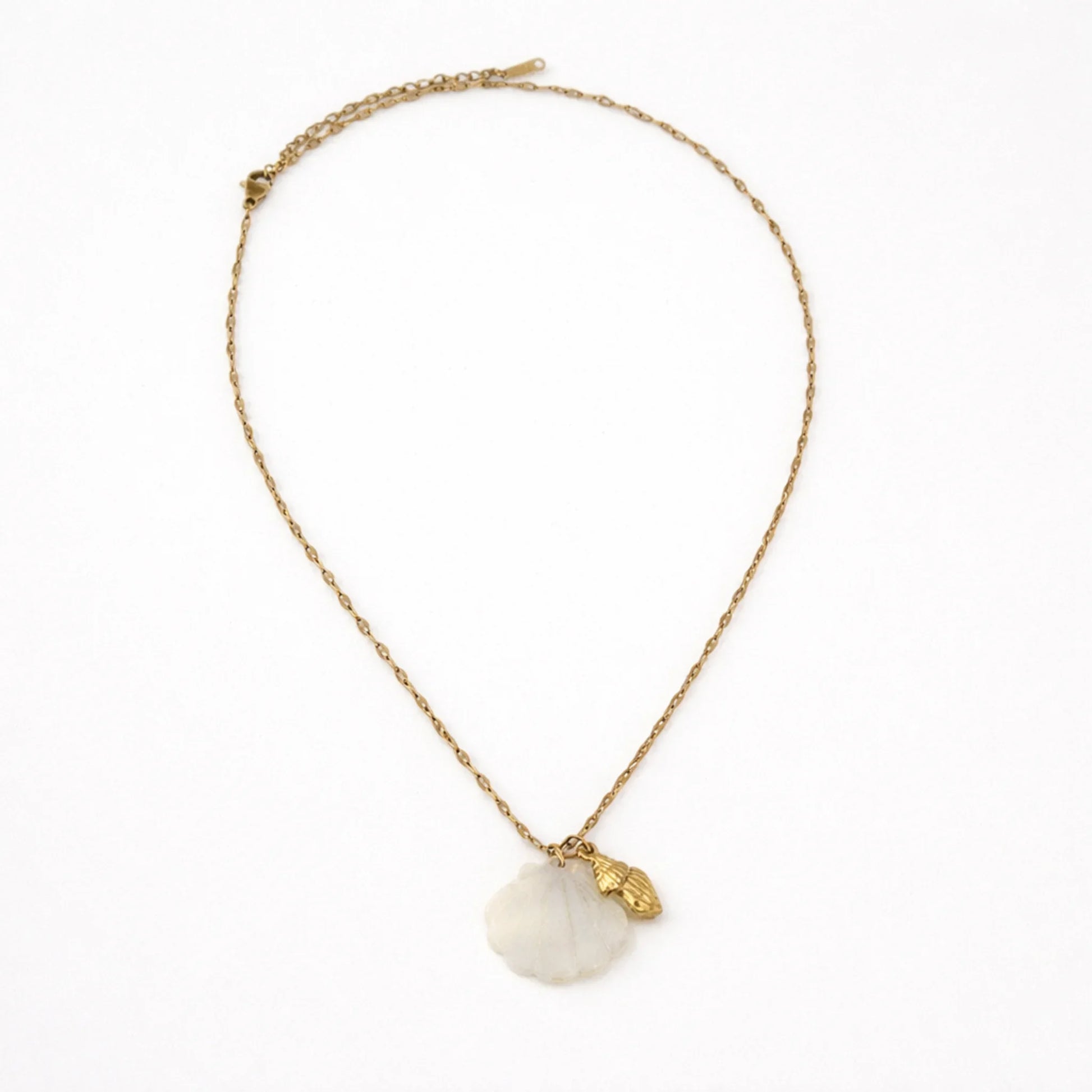 Gold chain necklace with mother of pearl shell pendant shown in full length flat lay on white background