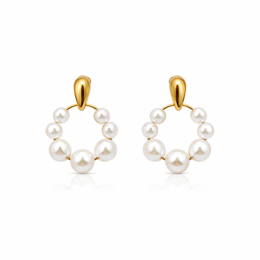 Pair of pearl hoop earrings with gold hooks on a white background