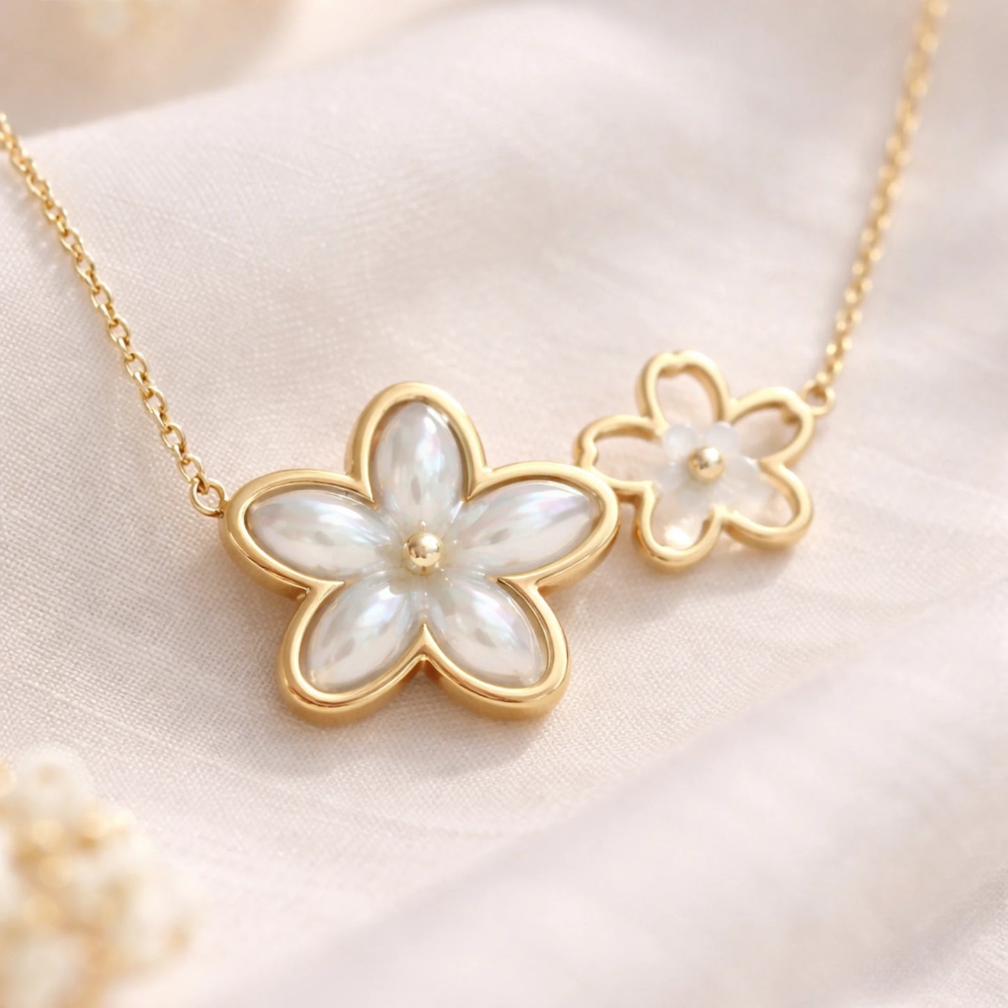 Gold necklace with a flower-shaped pendant on a soft background