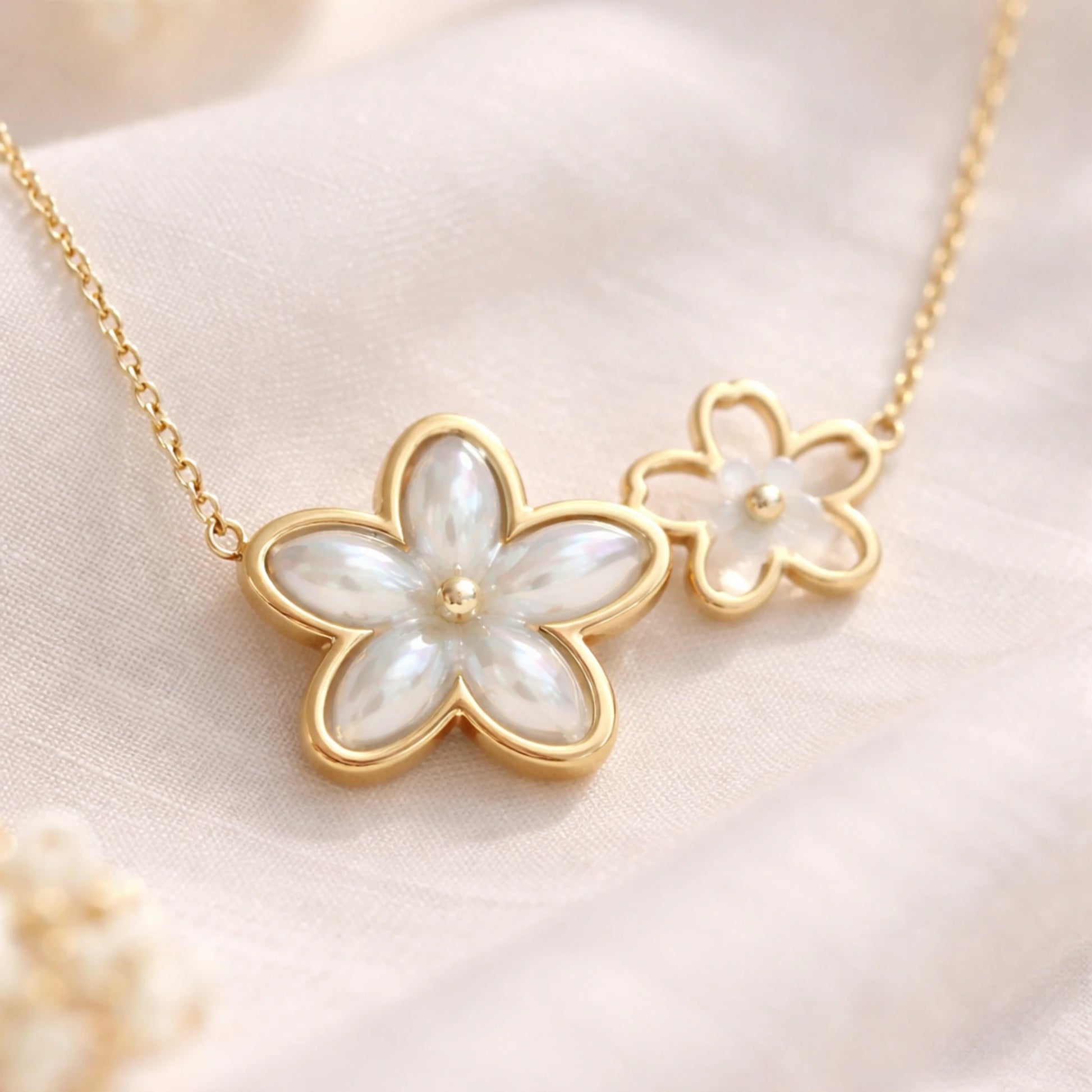 Gold necklace with a flower-shaped pendant on a soft background