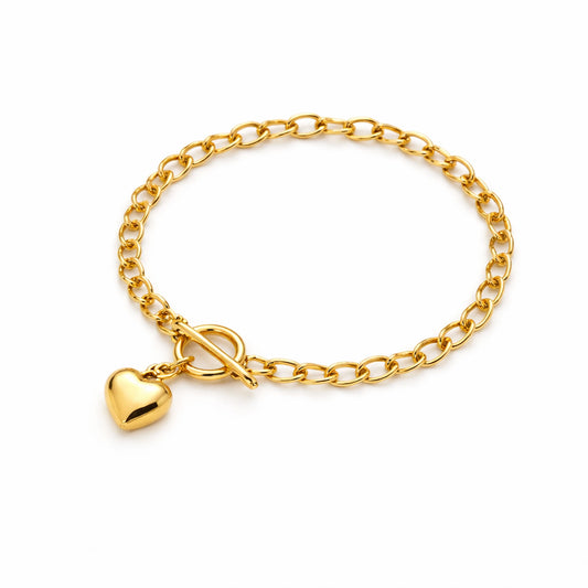 Gold chain bracelet with a heart-shaped charm on a white background