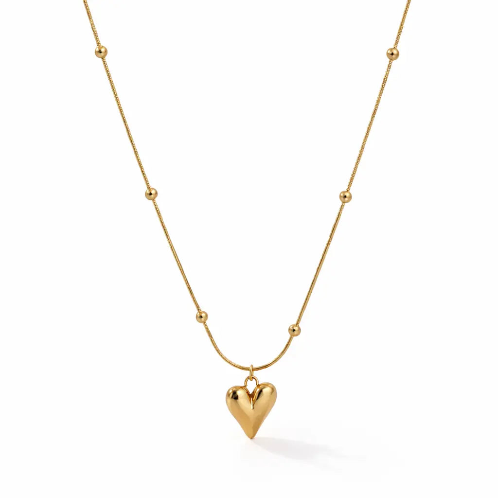 Gold heart pendant necklace with delicate bead chain on white background, minimal everyday jewelryy
