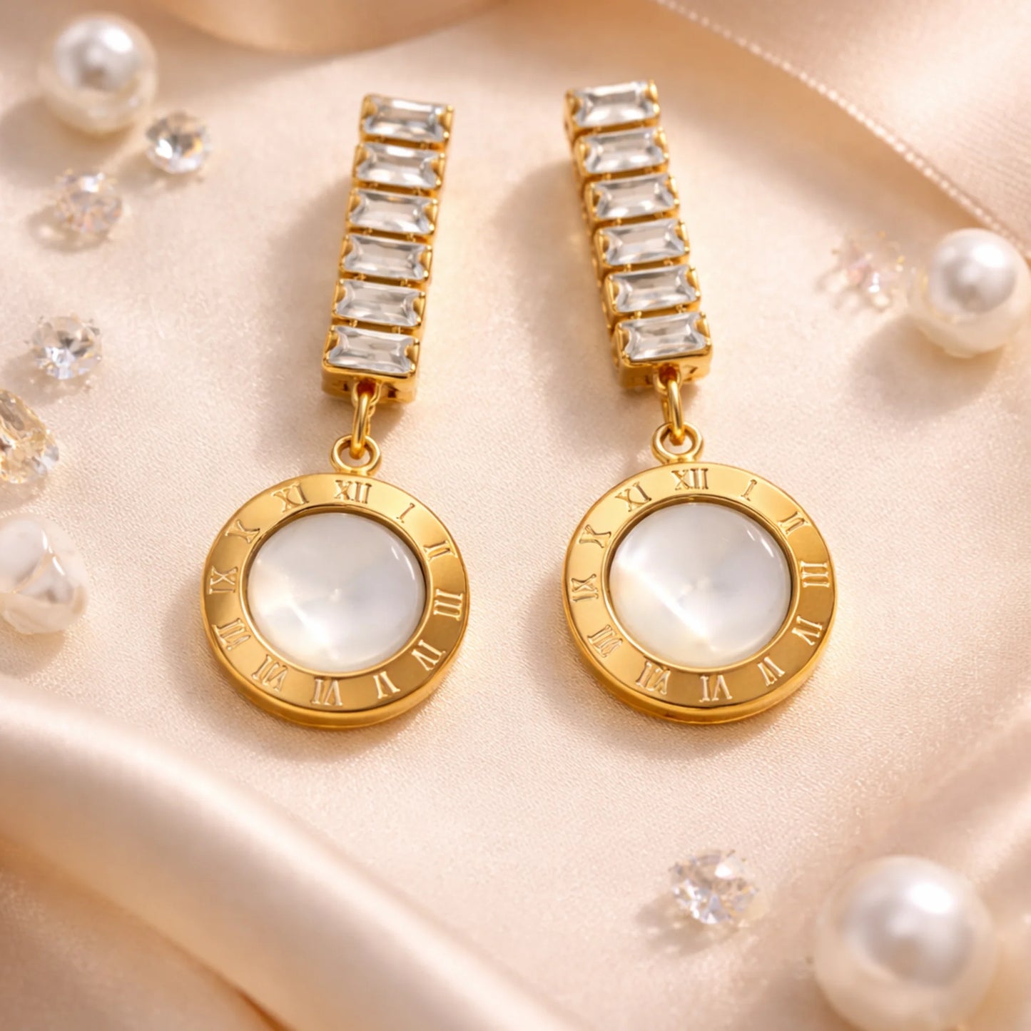 Gold earrings with white gemstones on a beige fabric background