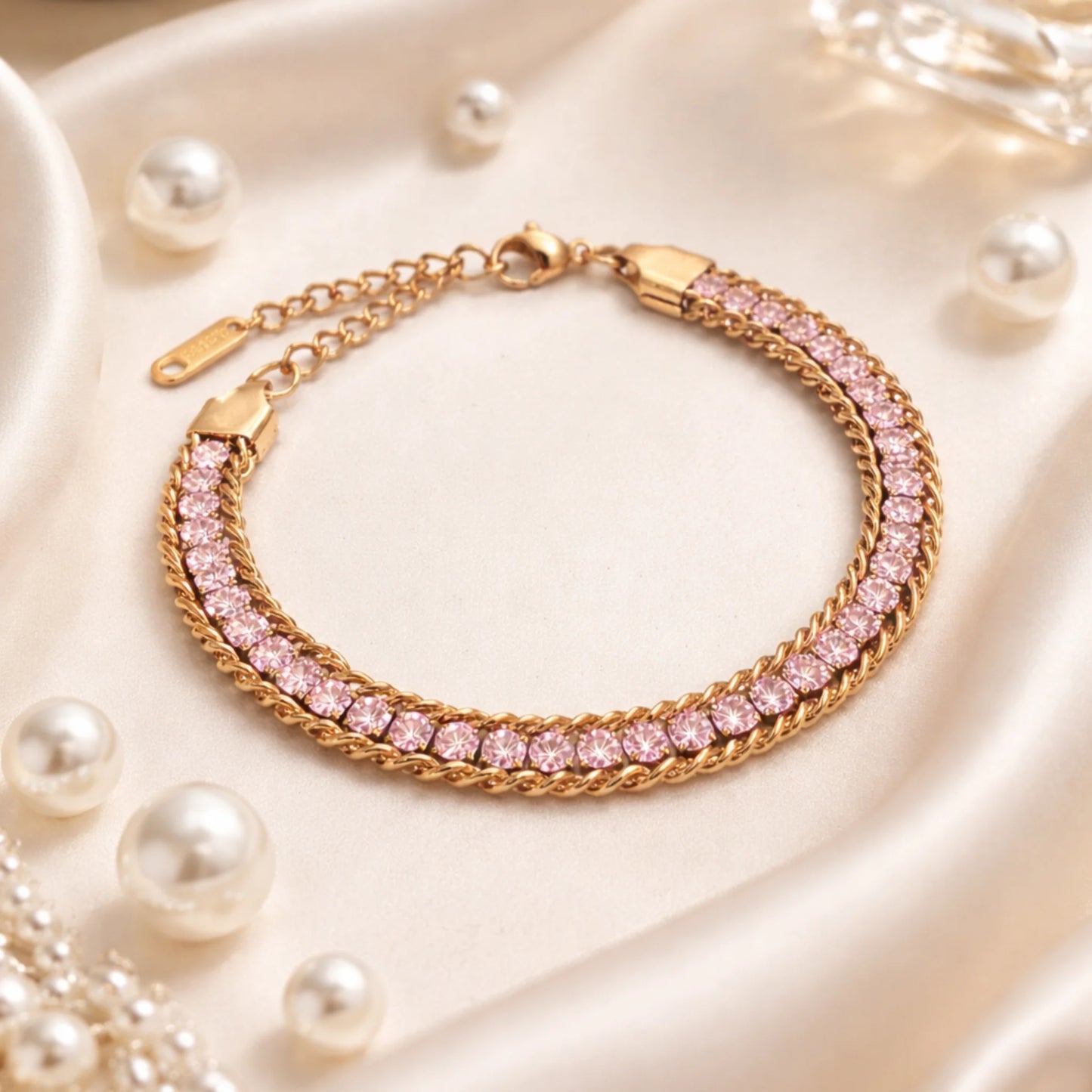 Gold bracelet with pink gemstones on a soft white background