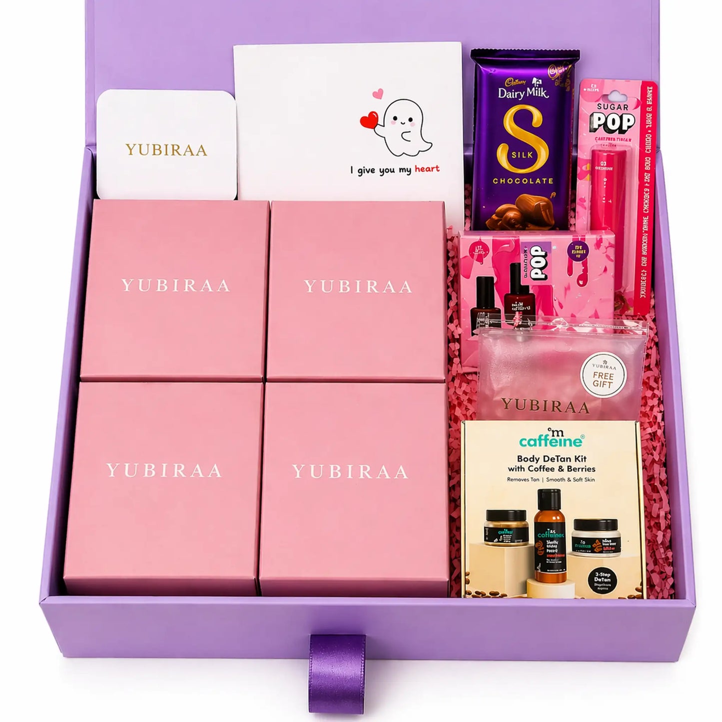 Gift set with pink boxes, chocolate, and other items on a white background