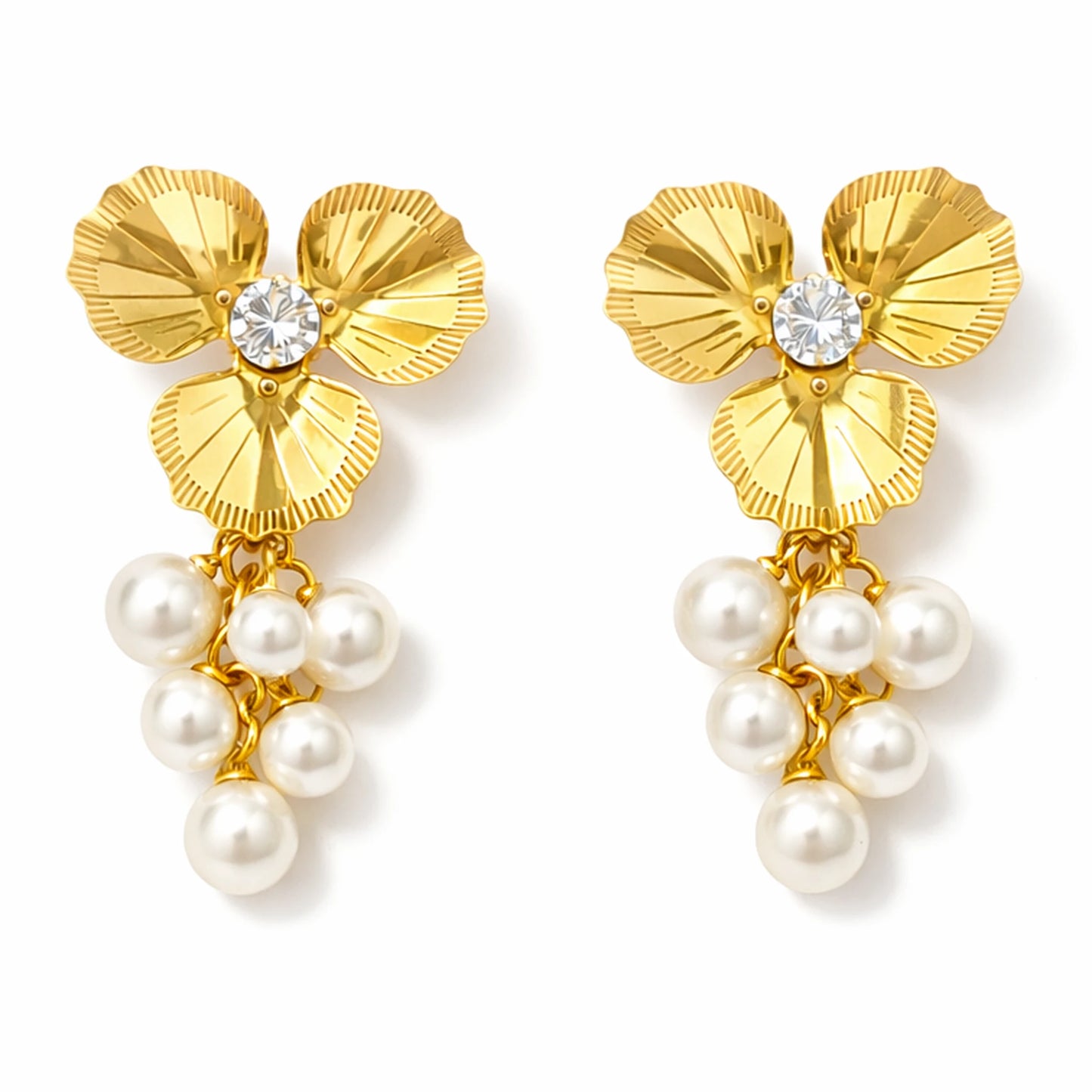 Gold floral earrings with pearl drops on a white background