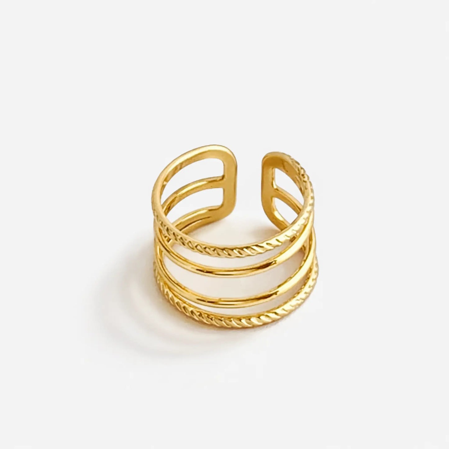 Top view of YUBIRAA layered gold stack ring featuring intertwined smooth and textured bands