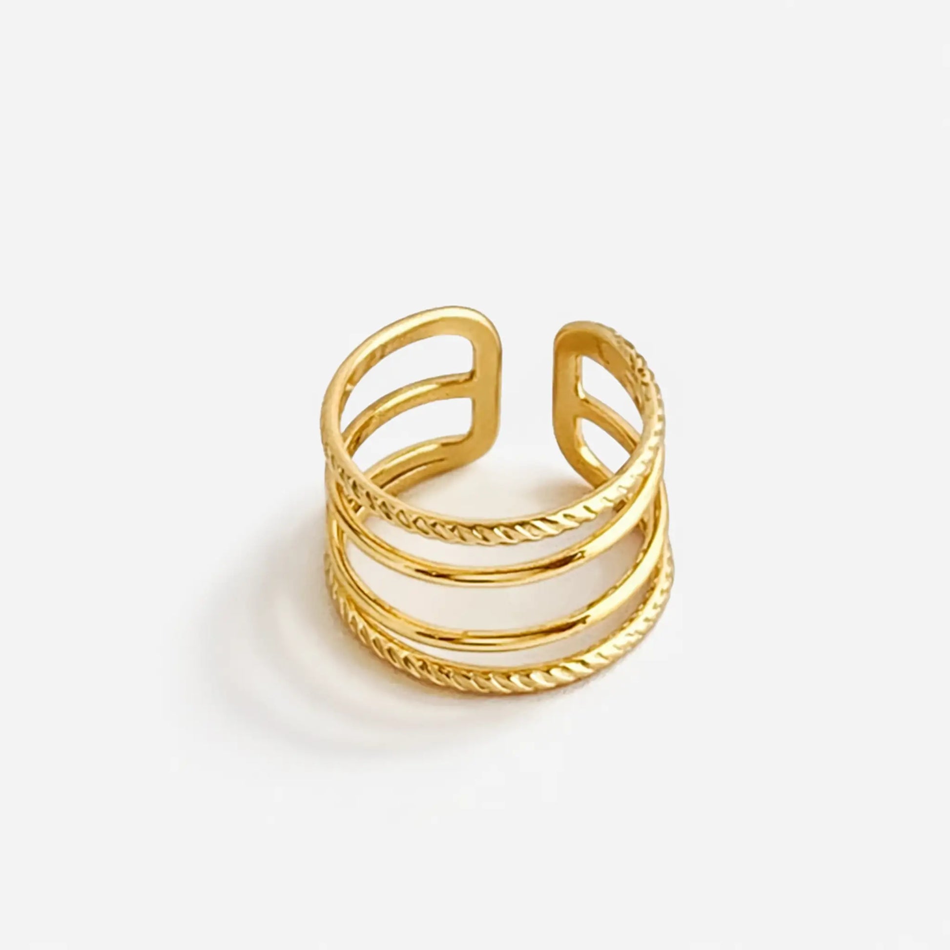 Top view of YUBIRAA layered gold stack ring featuring intertwined smooth and textured bands