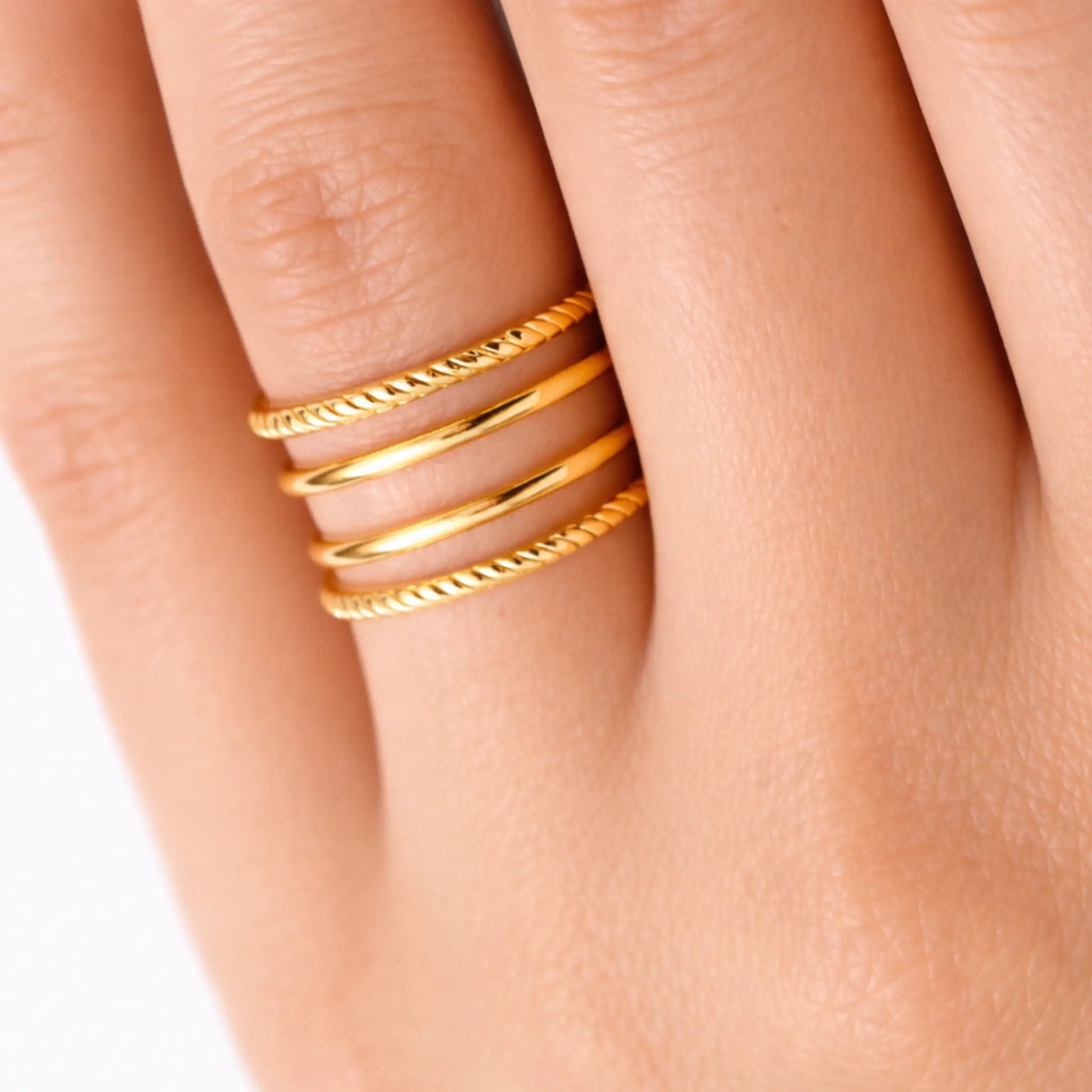 YUBIRAA adjustable gold stack ring worn on finger, showcasing modern layered statement design