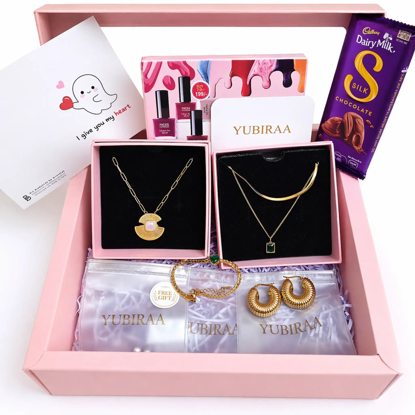 Jewelry set with necklaces, earrings, and a chocolate bar in a pink box labeled 'YUBIRAA'.