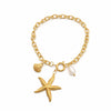 Gold bracelet with starfish, shell, and pearl charm on a white background