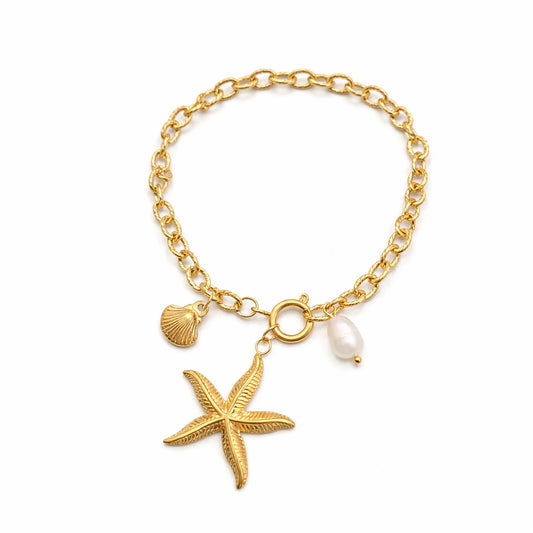 Gold bracelet with starfish, shell, and pearl charm on a white background