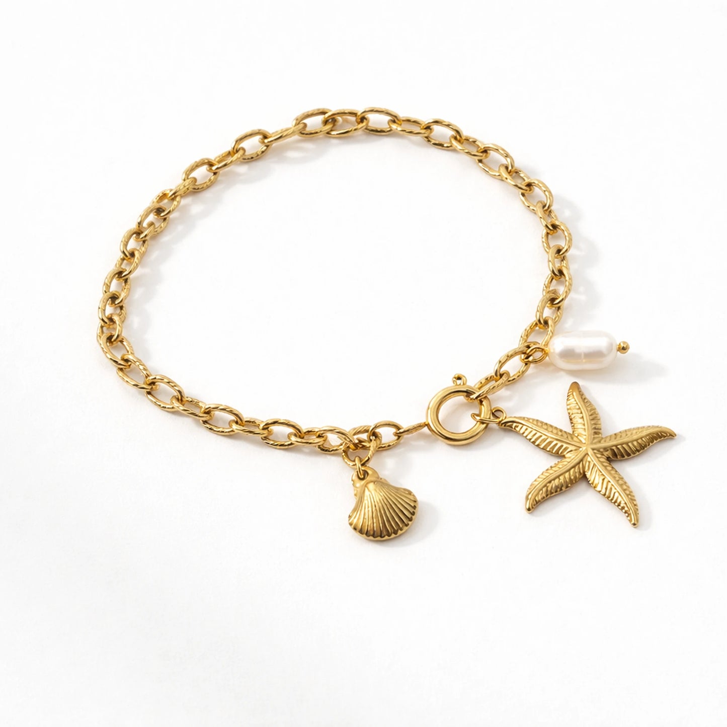 Gold bracelet with starfish and shell charms on a white background