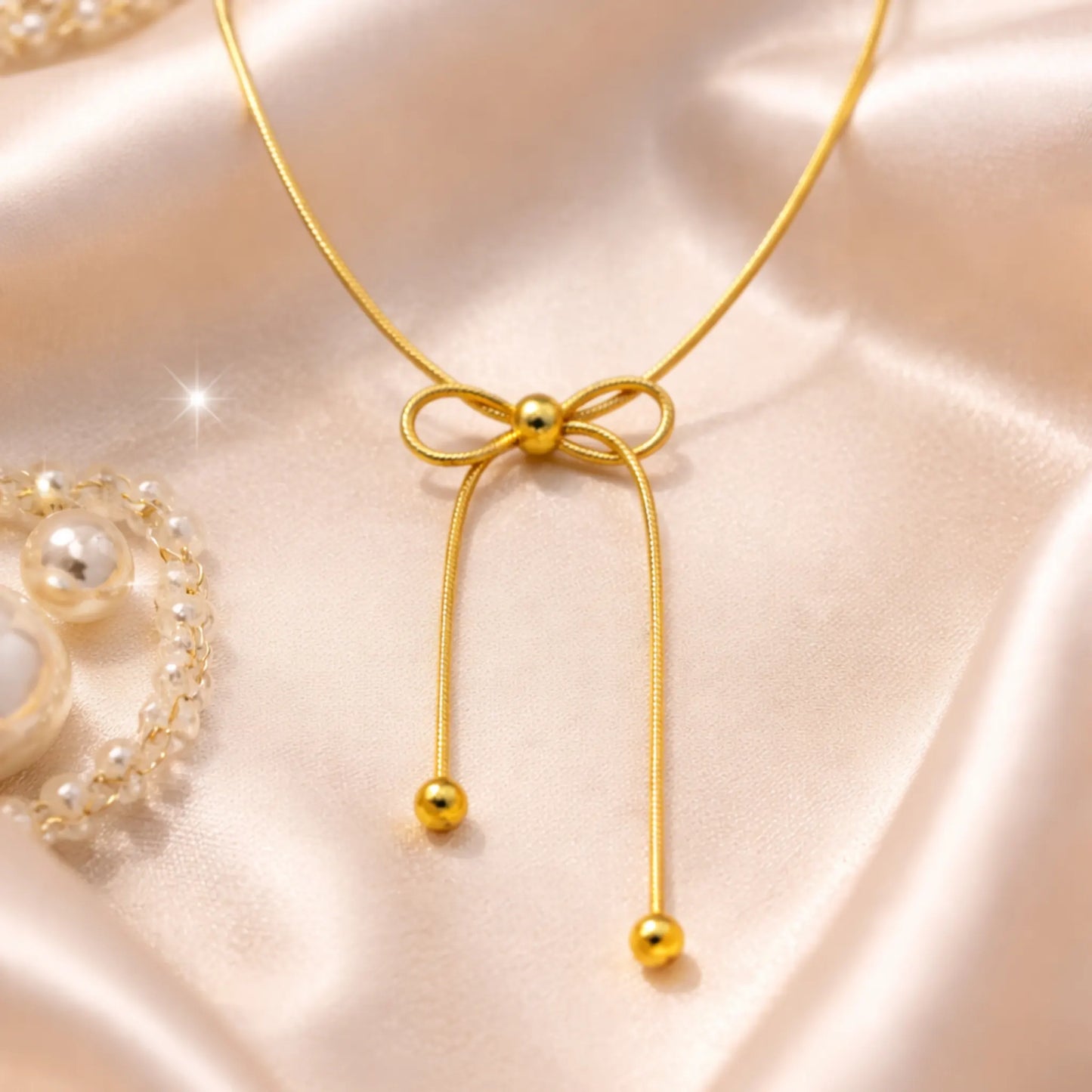 Yubiraa Bow Slider Necklace styled on satin fabric with soft luxury aesthetic