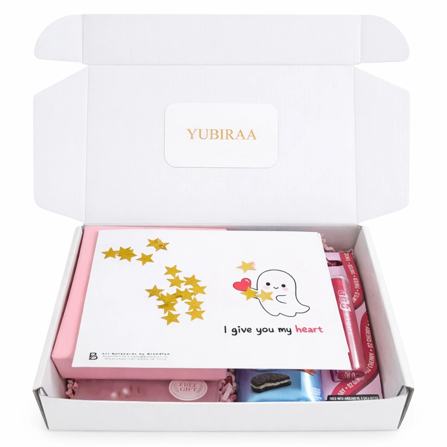 Open white box containing a card, jewellery and gift items .