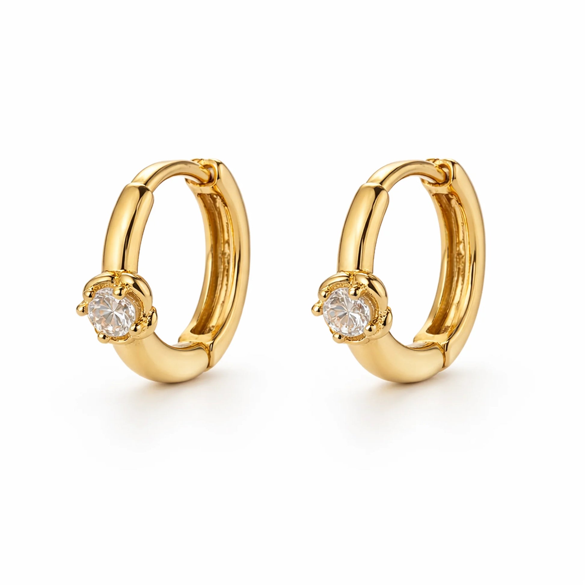 Gold hoop earrings with clear gemstones on a white background