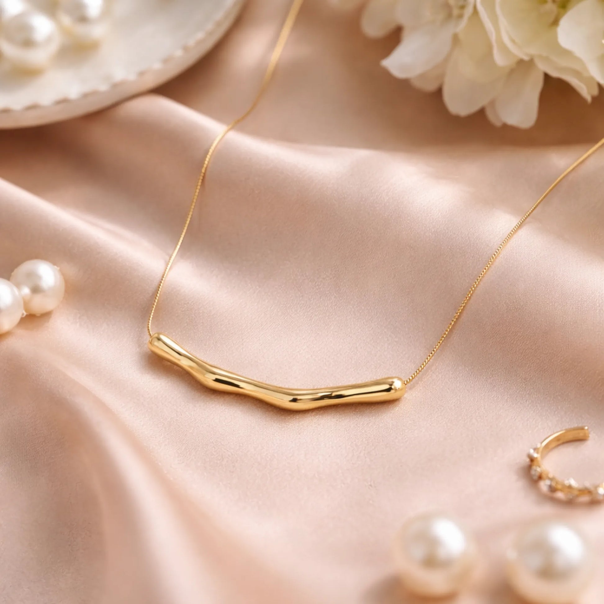 Yubiraa Wave Bar Necklace styled in elegant satin lifestyle setting