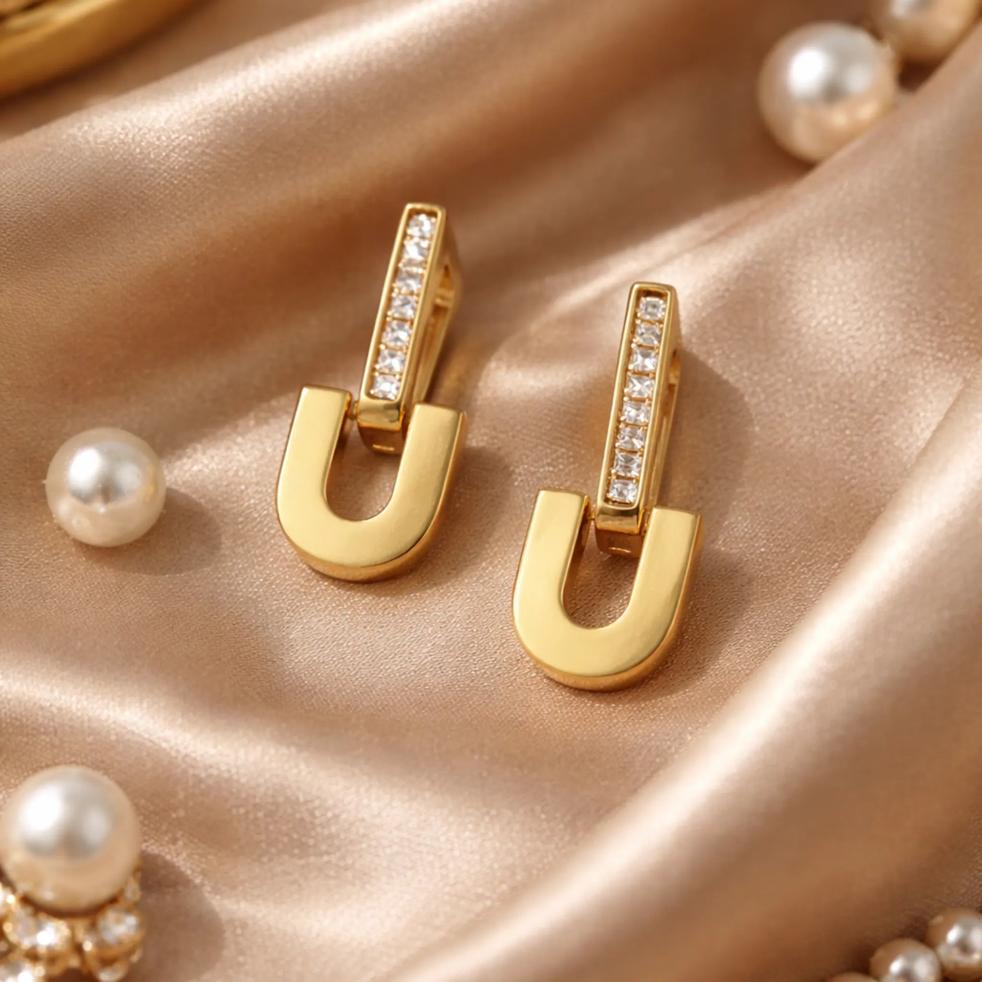YUBIRAA Glowlock gold-plated anti- tarnish U-shaped earrings styled on satin fabric with pearls for a luxurious lifestyle jewelry aesthetic