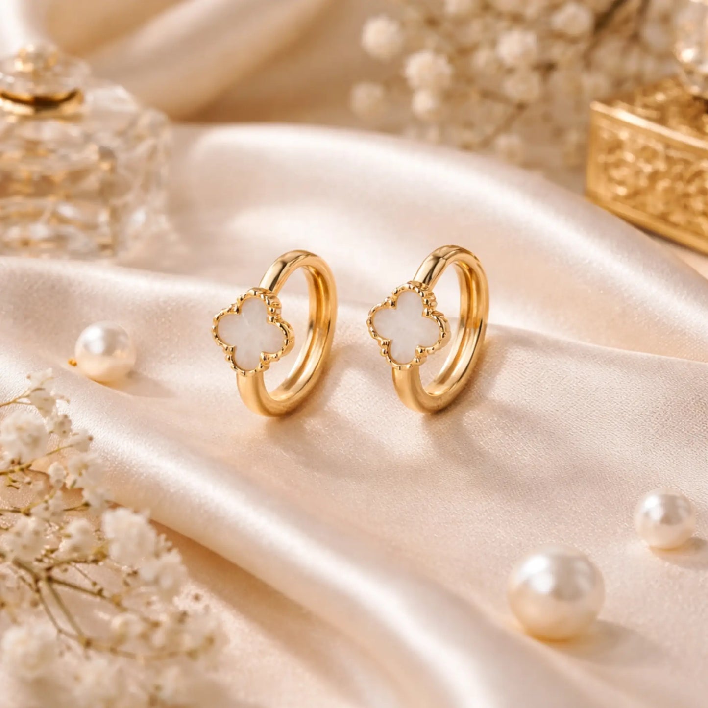 Eterna Bloom hoop earrings by YUBIRAA featuring white clover design with anti tarnish gold polish styled on satin fabric with pearls