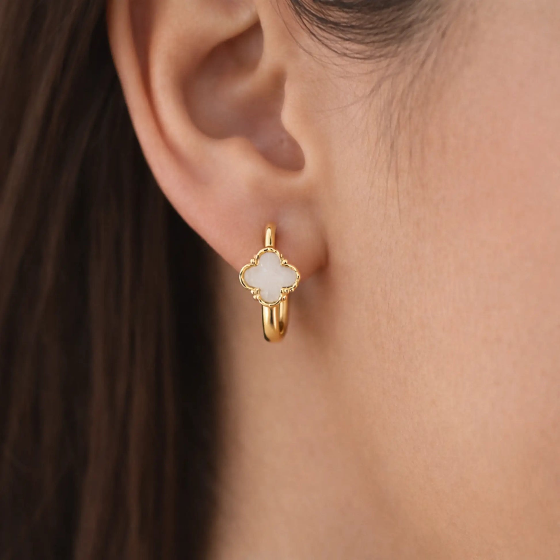 Model wearing YUBIRAA Eterna Bloom hoop earrings with white clover design and anti tarnish gold polish