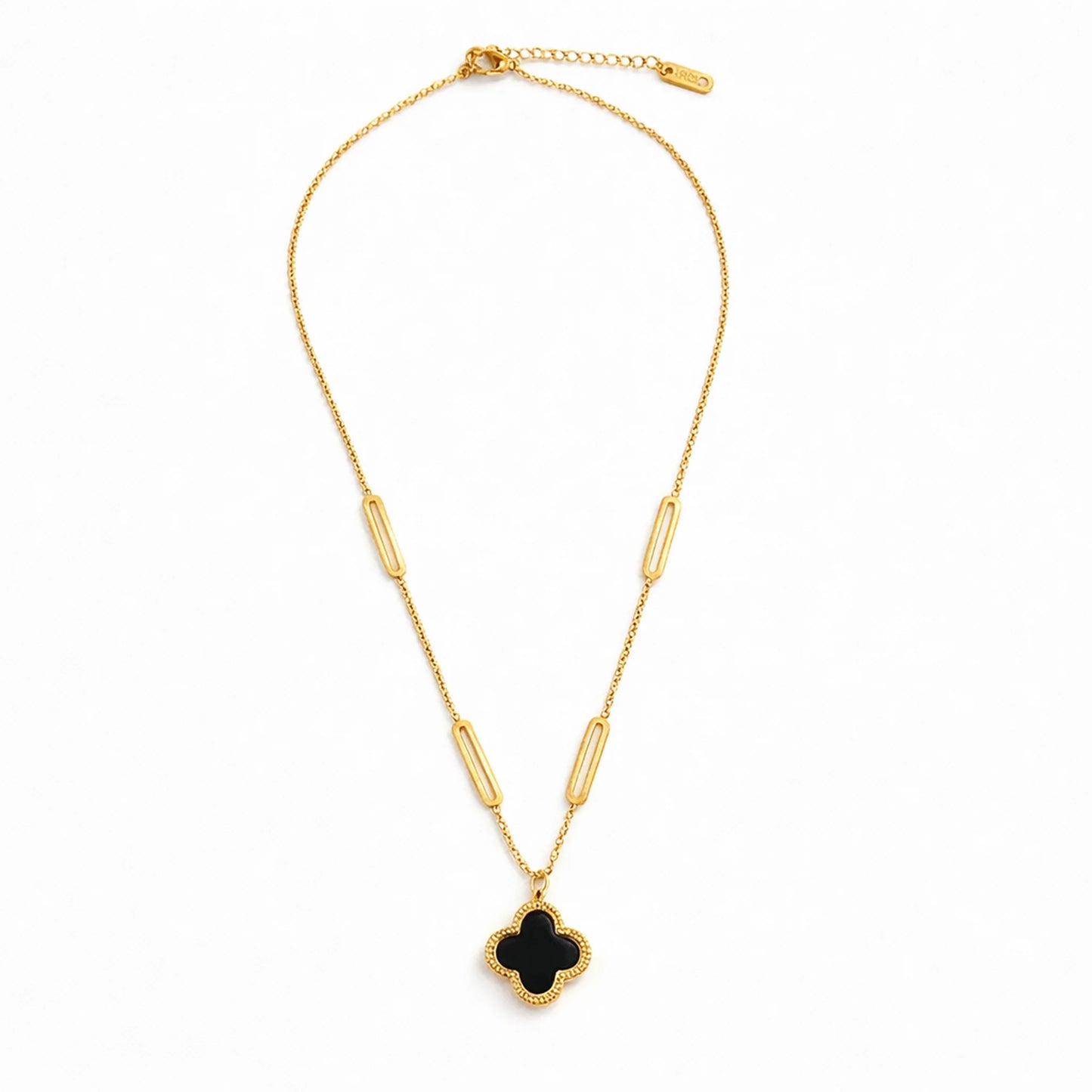 Flat lay of Yubiraa Final Ivory Glow Clover Necklace featuring black clover pendant and gold plated chain”