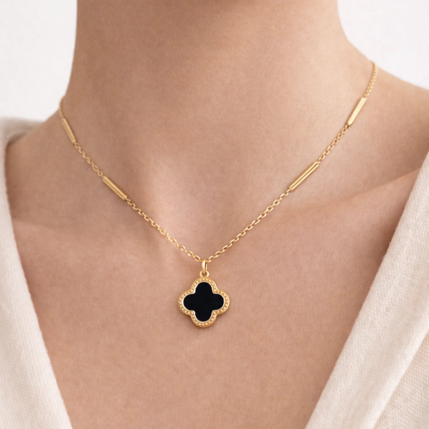 Model wearing Yubiraa Final Ivory Glow Clover Necklace with black clover pendant in anti tarnish gold plated stainless steel, neck only view