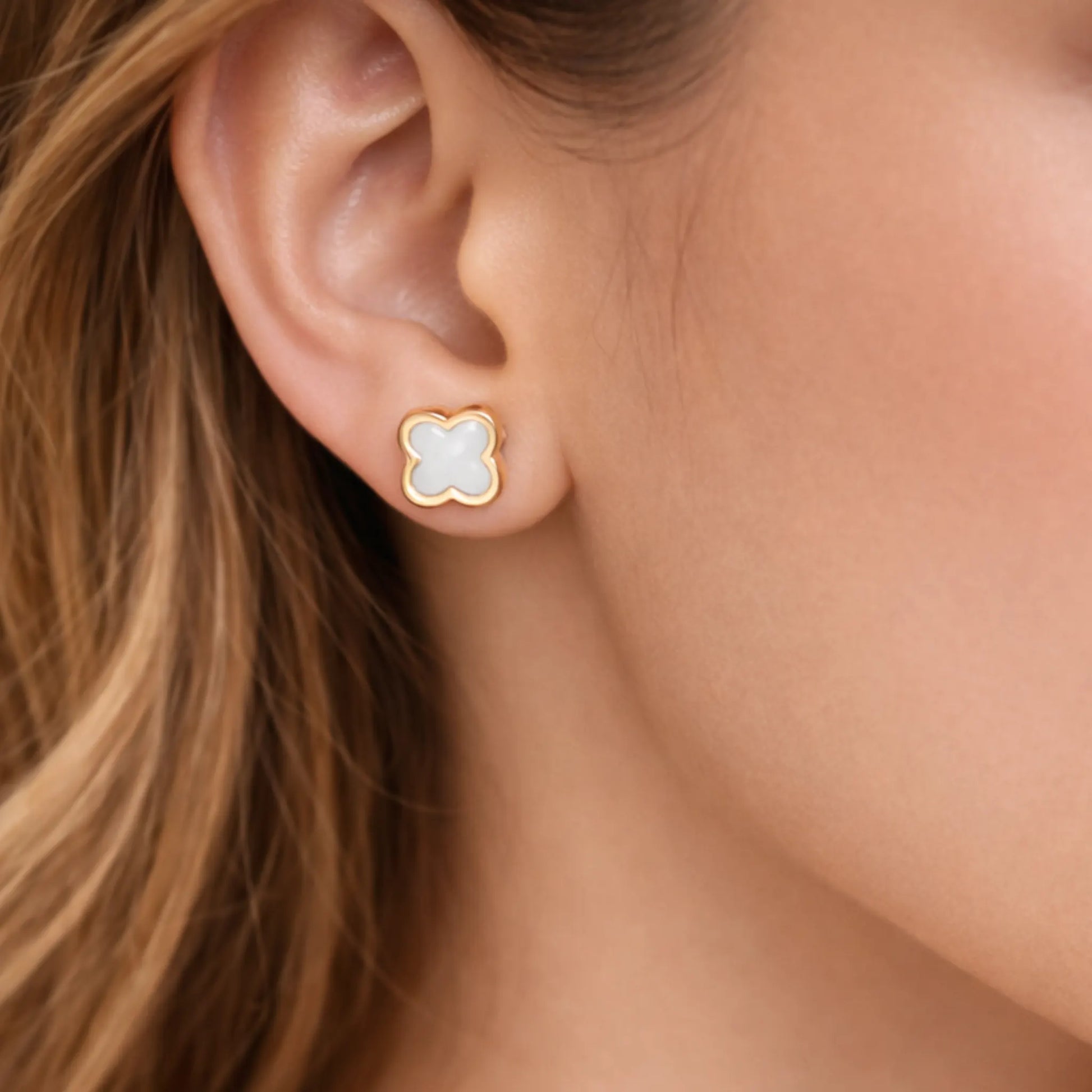 Yubiraa white clover stud earrings worn by model, minimal gold plated floral studs for everyday wear