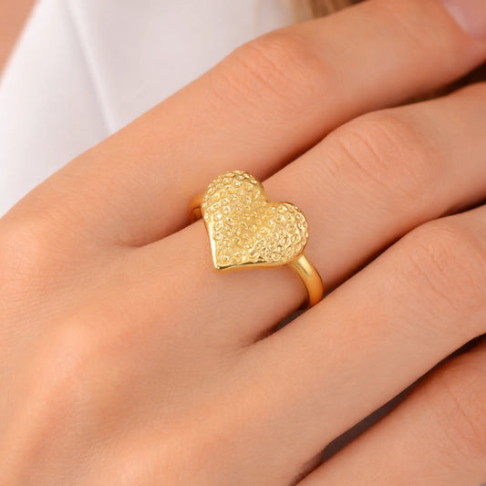 Model wearing gold textured heart adjustable ring on finger